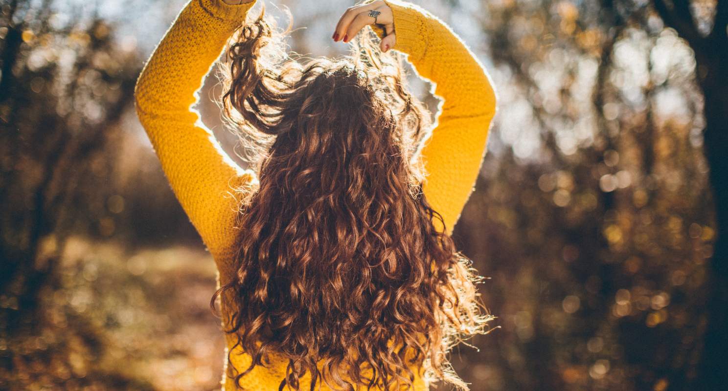 2. Voluminous Natural Curls With Side Part