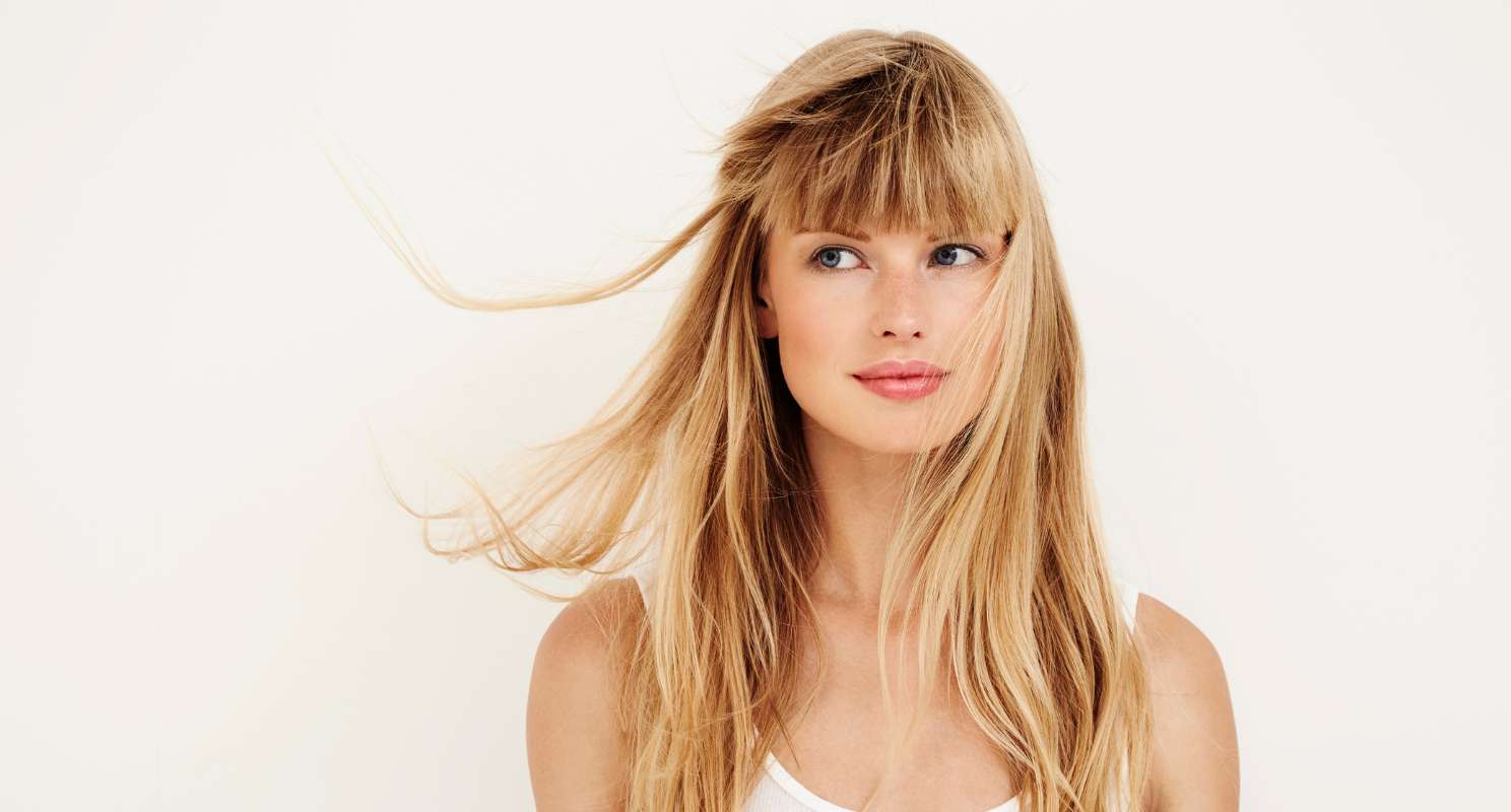 15. Layered Blonde Balayage With Dimensional Blends And Wispy Bangs